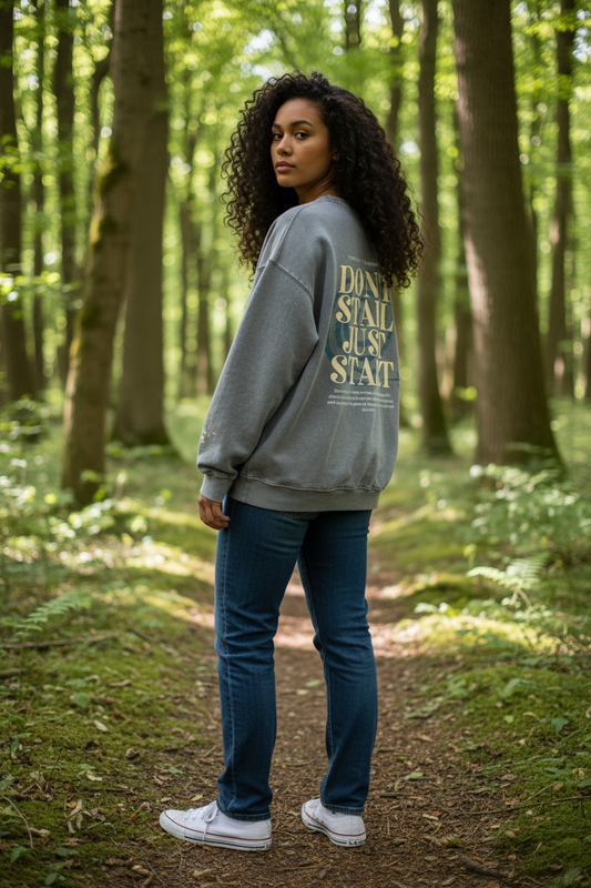 Person wearing a sweatshirt with text in a forest setting