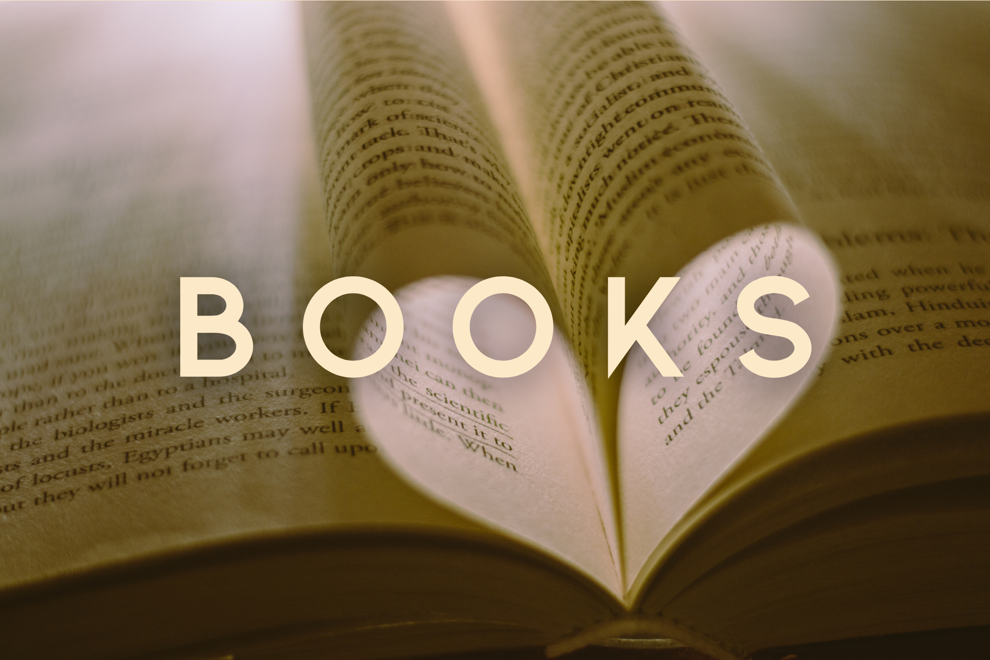 Open book with heart shape formed by pages and 'BOOKS' text overlay.