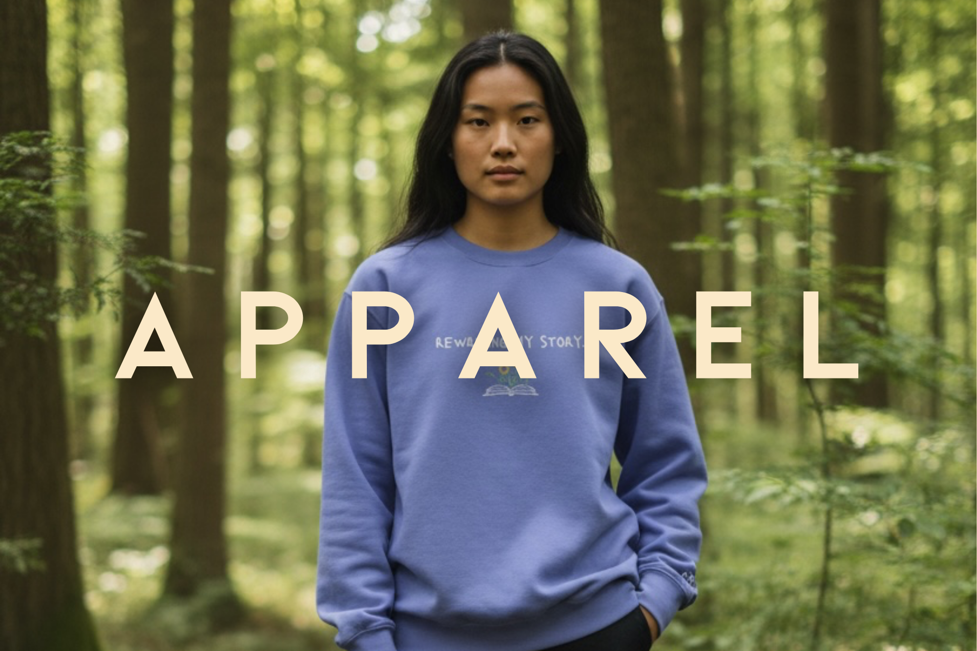 Person wearing a blue sweatshirt with 'APPAREL' text in a forest setting