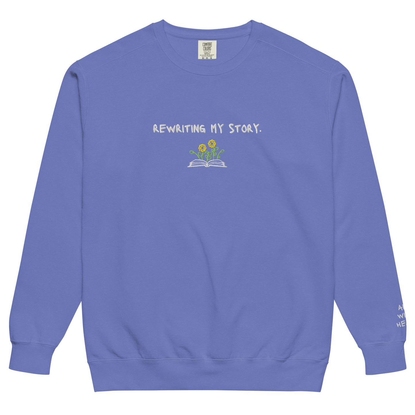 A blue Crewneck that says “Rewriting My Story” with an open book and flowers design.