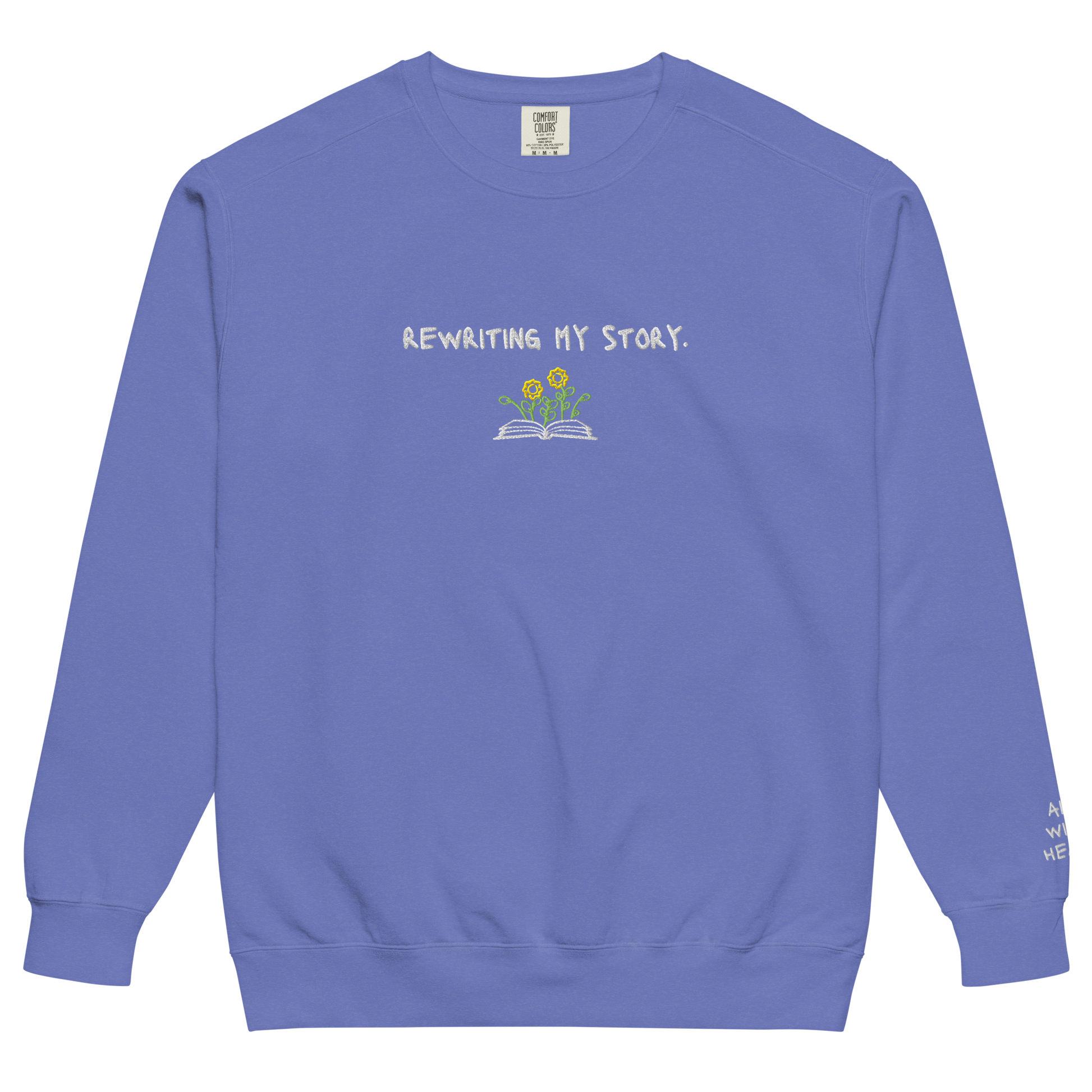 A blue Crewneck that says “Rewriting My Story” with an open book and flowers design.