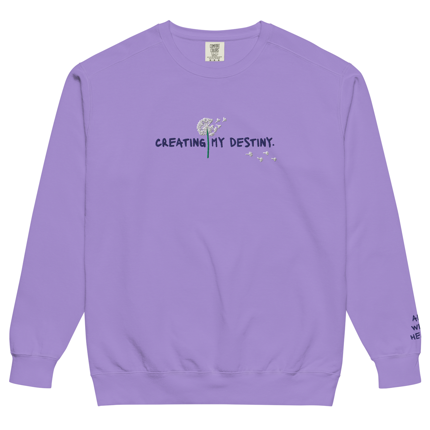 The front side of a purple Crewneck the says “Creating My Destiny” with a dandelion design.
