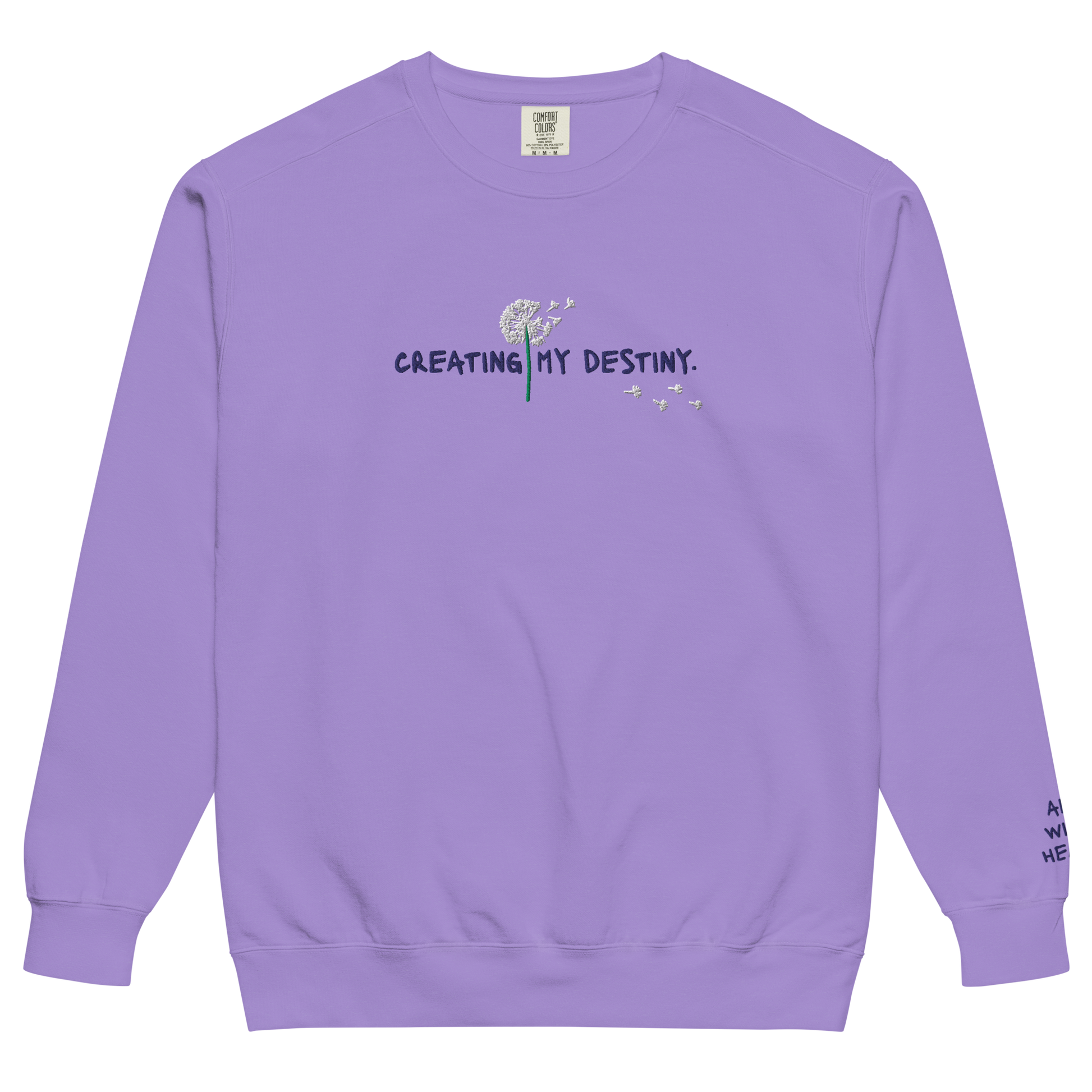 The front side of a purple Crewneck the says “Creating My Destiny” with a dandelion design.